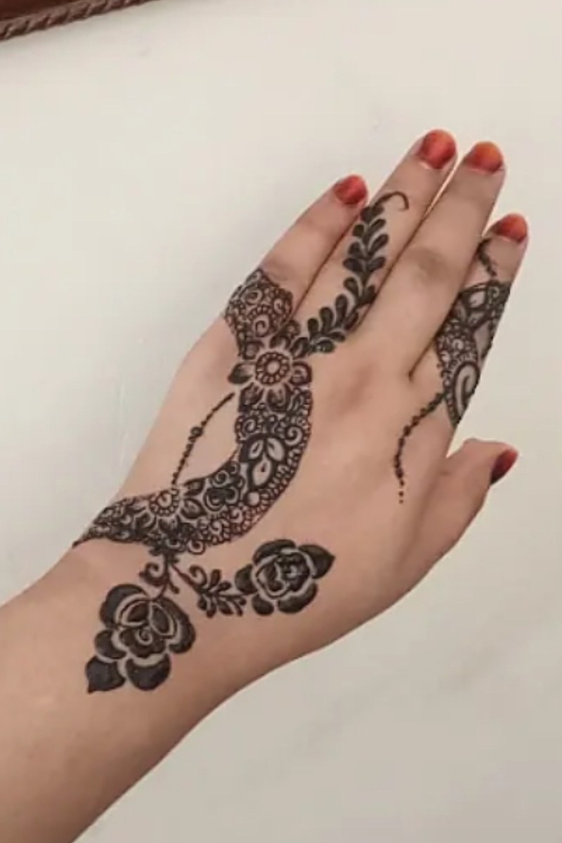 Arabic trail mehndi with roses and vines on the back of the hand