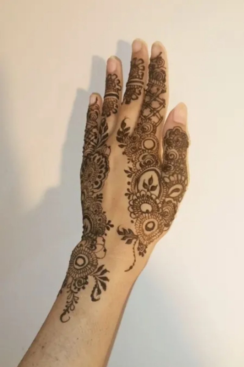 Floral net mehndi design covering the back of the hand and fingers
